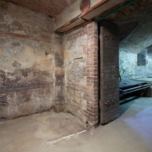 Old, empty basement with brick walls and wooden portal