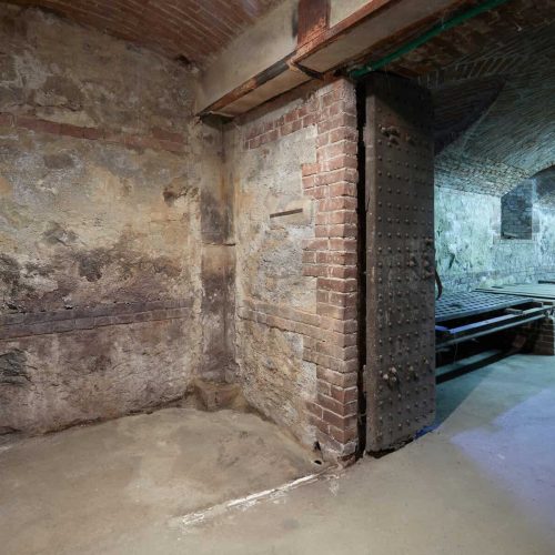 Old, empty basement with brick walls and wooden portal